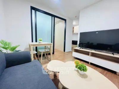 Modern living room with sleek furniture and large TV, perfect for relaxation and entertainment.