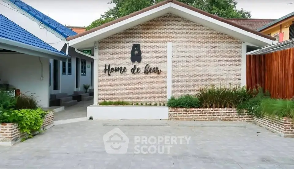 Charming brick exterior of Home de Bear with lush greenery and modern design.