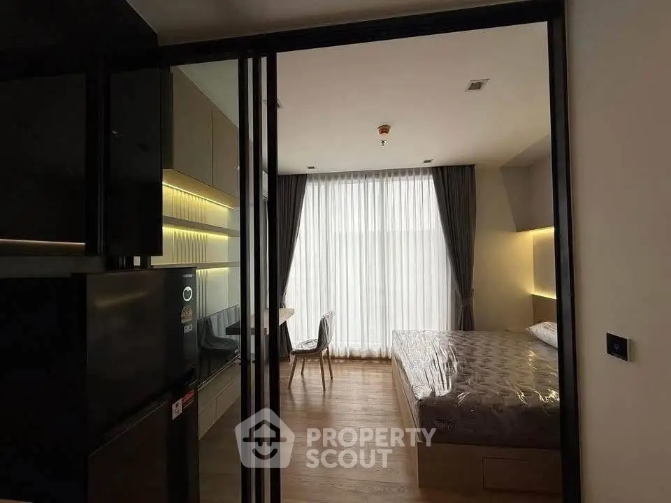 Modern bedroom with floor-to-ceiling window and sleek furnishings