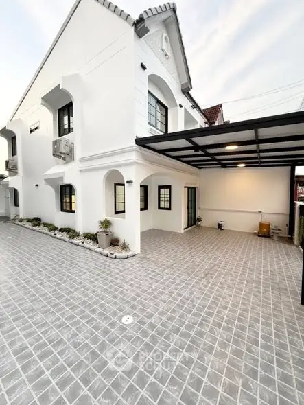 Stunning modern white exterior with spacious tiled driveway and elegant architectural details.