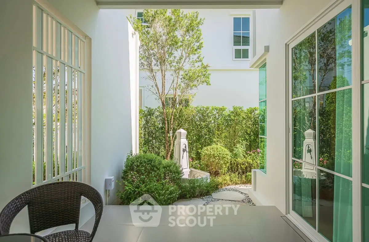 Charming patio view with lush greenery and modern architecture, perfect for relaxation and outdoor enjoyment.