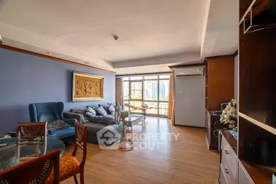 Spacious living room with modern decor and large windows offering city views.