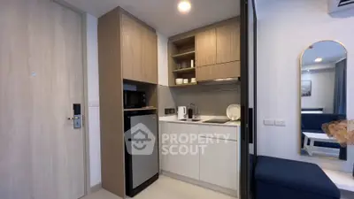 Modern compact kitchen with sleek cabinetry and integrated appliances in a stylish apartment.