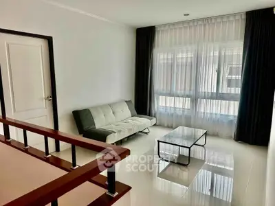 Modern living room with sleek sofa and large window, perfect for natural light lovers.