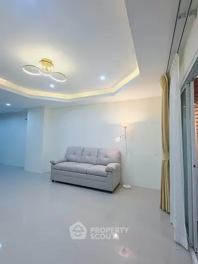 Spacious living room with modern lighting and cozy sofa in a bright apartment.