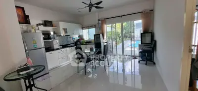 Modern open-plan kitchen and dining area with pool view