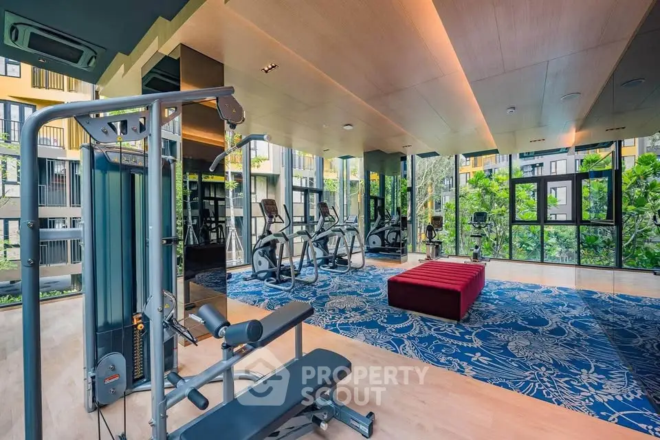 Luxurious gym with modern equipment and scenic garden views in upscale residential building.