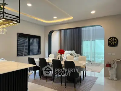 Luxurious open-plan dining and living area with modern decor and elegant lighting.