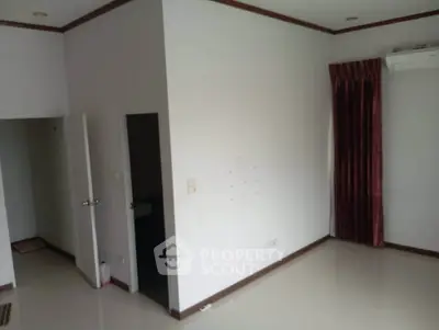 Spacious empty room with white walls and red curtains, ideal for customization.