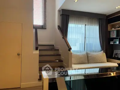 Modern living room with cozy seating and stylish staircase