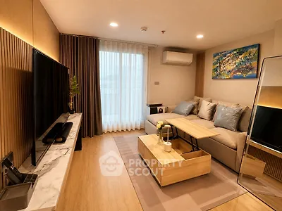 Modern living room with stylish decor, large TV, and cozy seating area in a contemporary apartment.