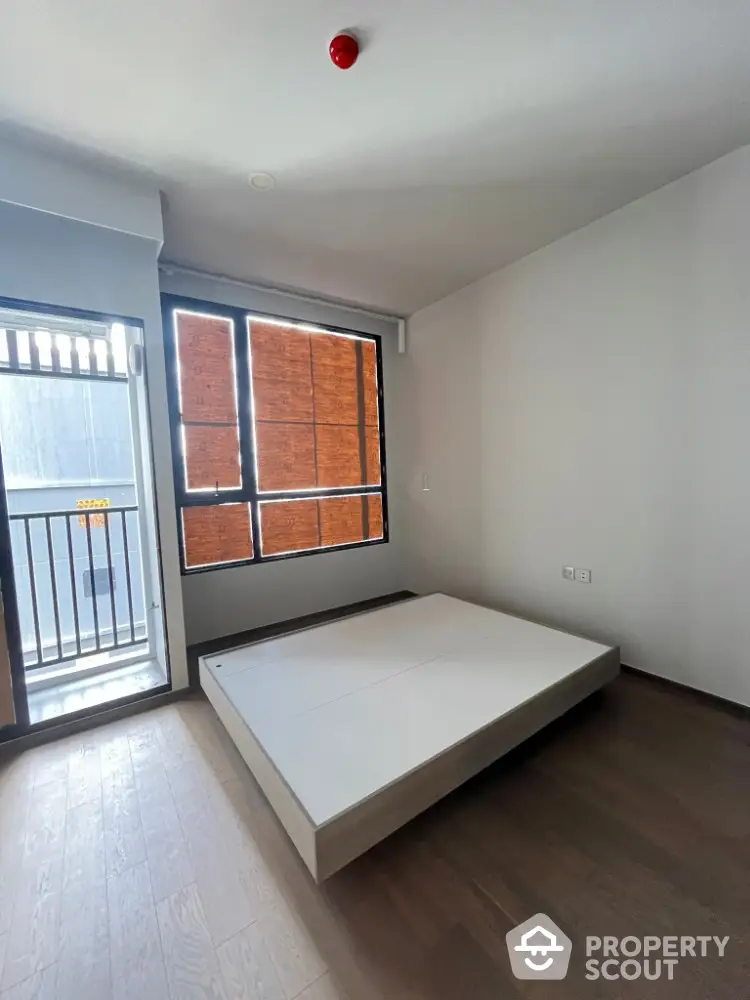 Modern minimalist bedroom with platform bed and balcony access