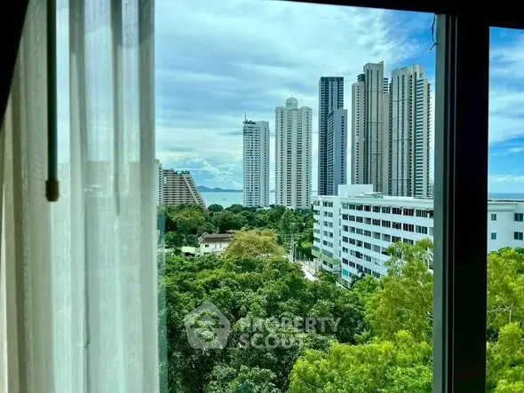 Stunning cityscape view from a high-rise window with lush greenery and modern skyscrapers.