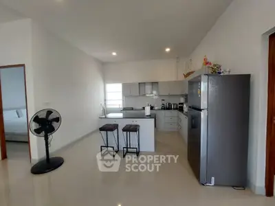 Modern kitchen with sleek design, featuring stainless steel appliances and breakfast bar in open layout.