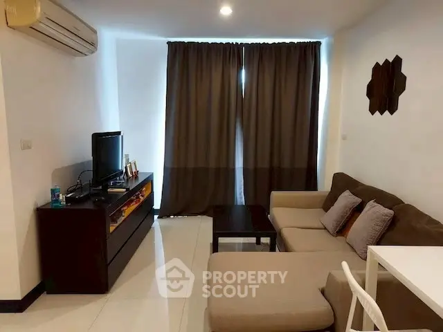Cozy living room with modern sofa and entertainment center, perfect for relaxation.