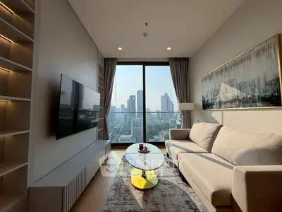 Modern living room with city view, stylish sofa, and wall-mounted TV in high-rise apartment.