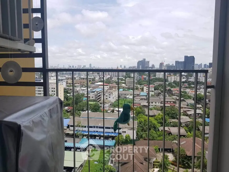 Stunning cityscape view from a high-rise balcony with urban skyline and lush greenery.