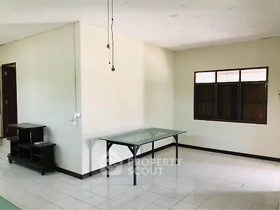 Spacious unfurnished room with tiled floor and large window, ideal for customization.