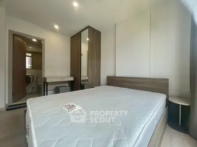 Modern bedroom with sleek design and ensuite bathroom in a stylish apartment.