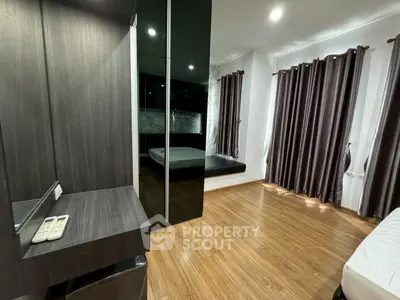 Spacious bedroom with wooden flooring and modern decor