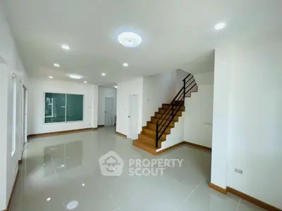 Spacious modern living room with elegant staircase and glossy tiled flooring