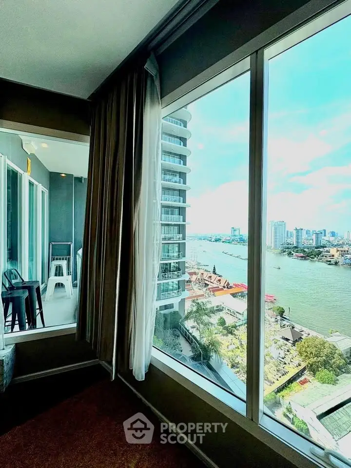 Stunning river view from modern apartment with large windows and balcony.