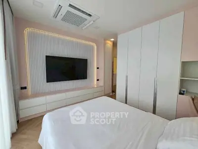 Modern bedroom with sleek built-in storage and large TV