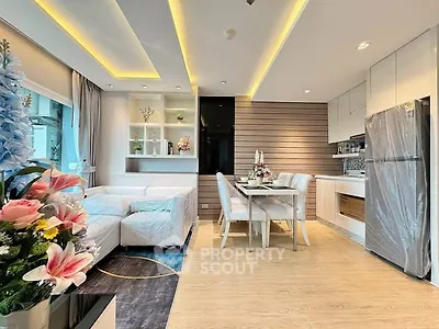 Modern open-layout living room and kitchen with elegant decor and natural light.