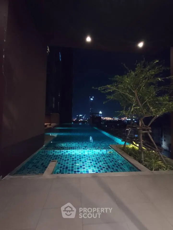 Luxurious rooftop pool with stunning city night view, perfect for relaxation and entertainment.