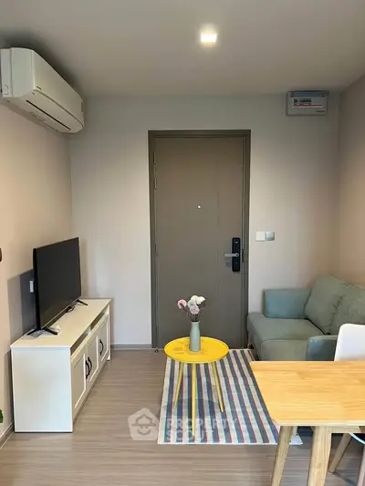 Cozy living room with modern decor, featuring a TV, sofa, and air conditioning.