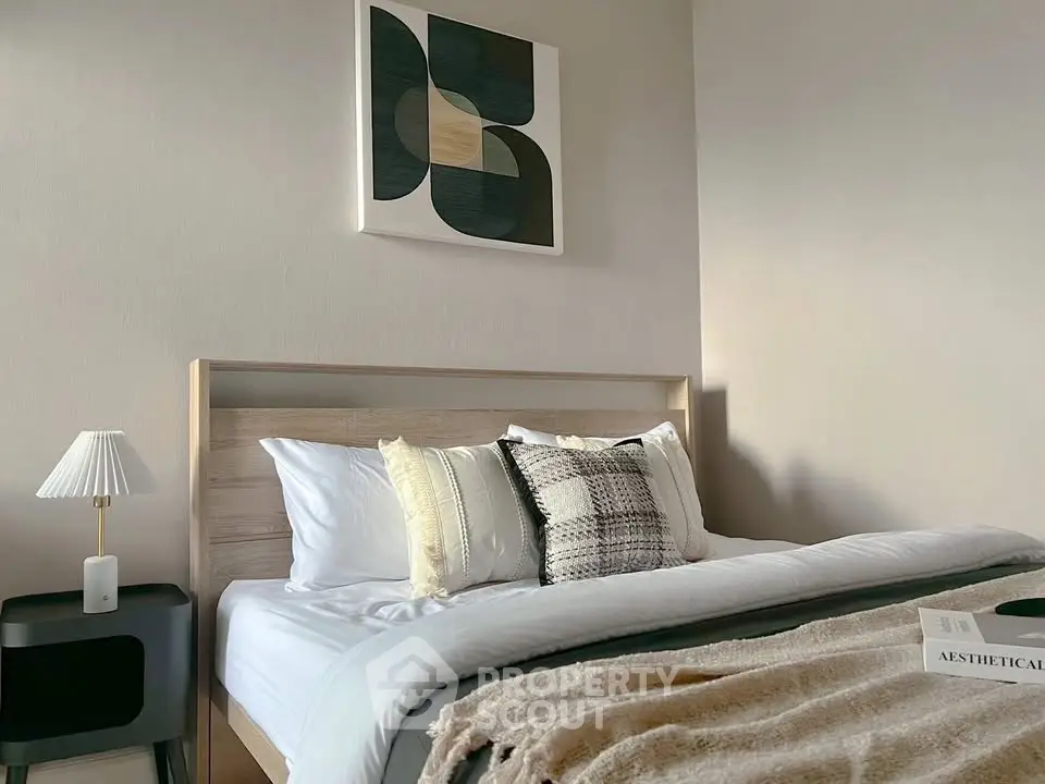 Cozy bedroom with modern decor and stylish artwork above the bed, perfect for relaxation.