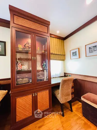 Charming study room with elegant wooden cabinet and cozy seating area.