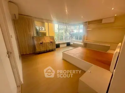 Spacious living room with large windows and modern decor in a stylish apartment.