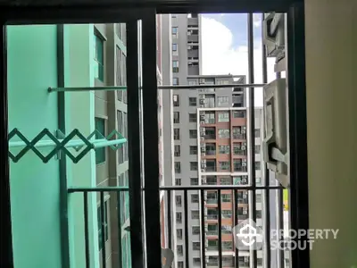 Modern apartment balcony with city view and laundry rack