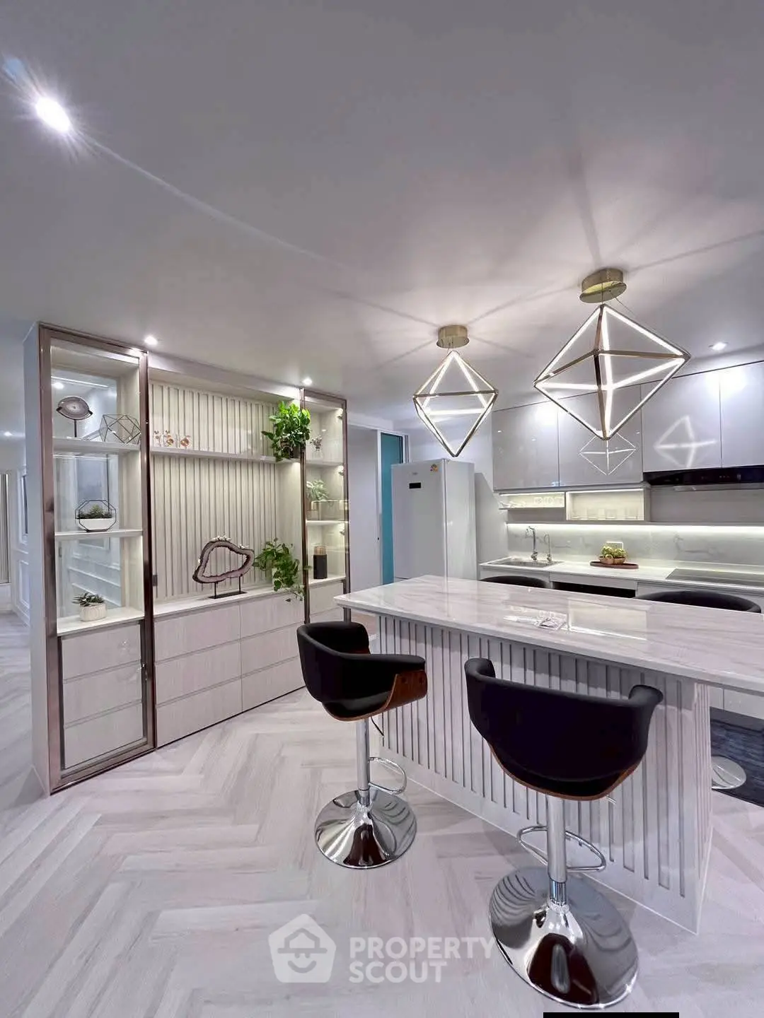 Modern kitchen with sleek design, featuring a breakfast bar and stylish lighting fixtures.
