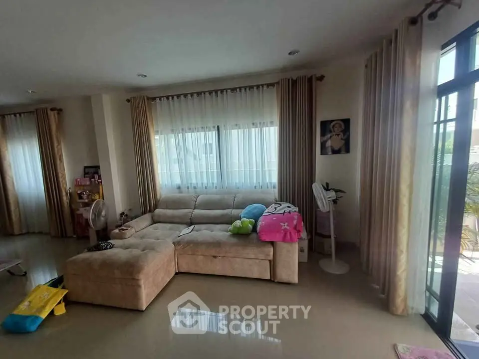 Spacious living room with large windows and cozy sectional sofa, perfect for family gatherings.