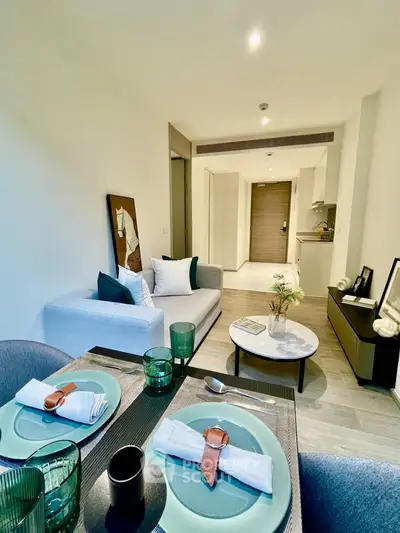 Modern open-plan living room and dining area with stylish decor and neutral tones.