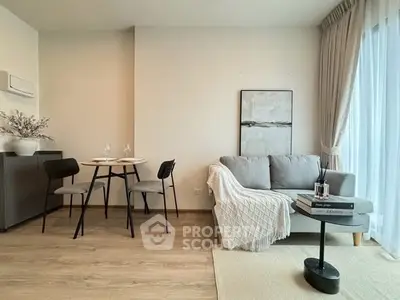 Modern living room with cozy sofa, dining area, and large window for natural light.