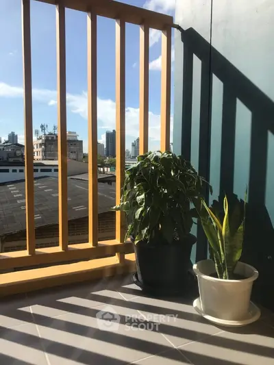 Charming balcony with city view and potted plants, perfect for relaxation.