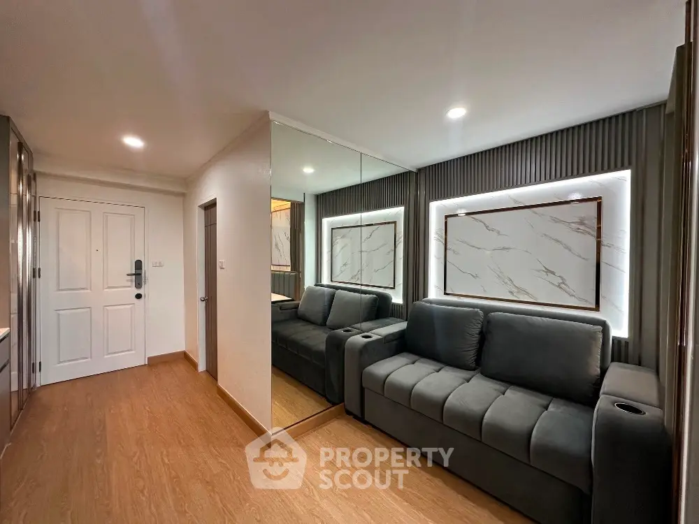 Modern living room with sleek design and mirrored wall, featuring a comfortable sofa and stylish decor.