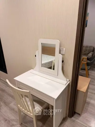 Cozy bedroom corner with elegant white vanity and chair, perfect for a serene morning routine.
