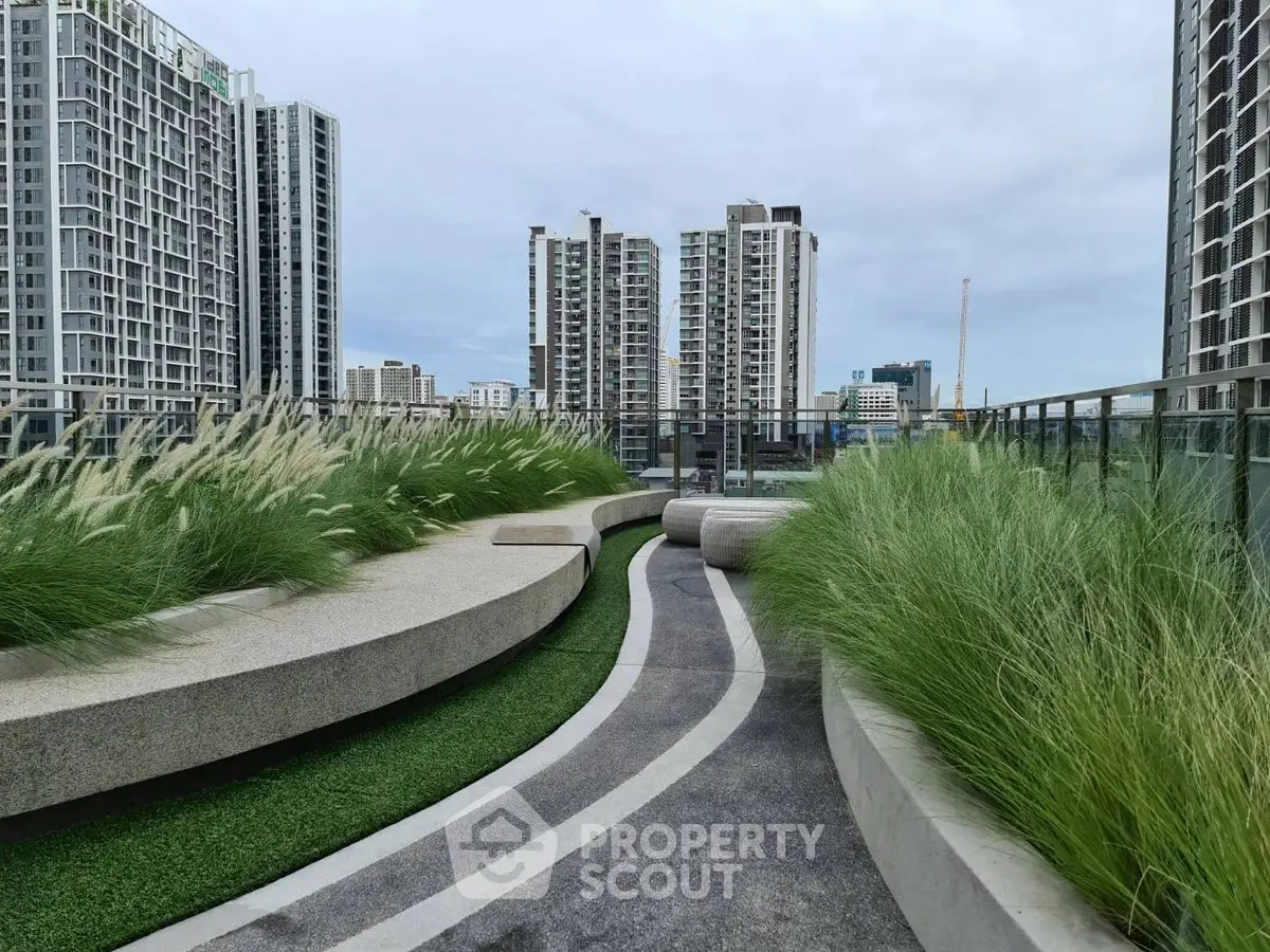 Modern rooftop garden with city skyline view, featuring sleek design and lush greenery.