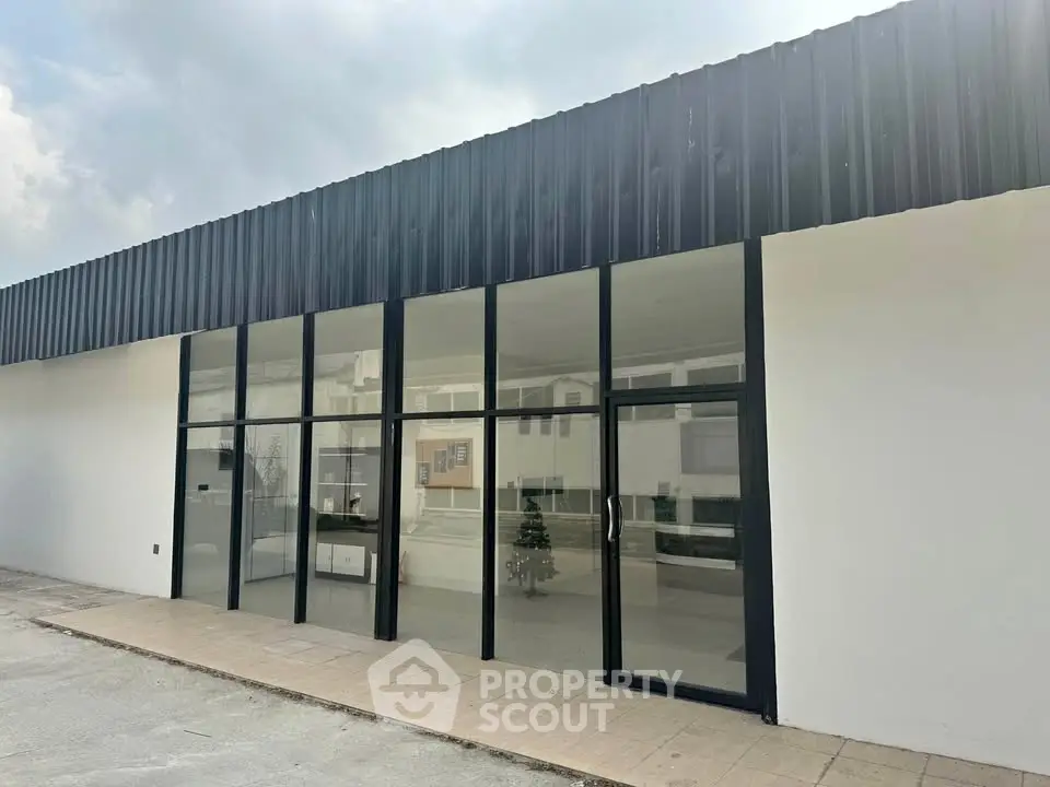 Modern commercial building exterior with large glass windows and sleek design.