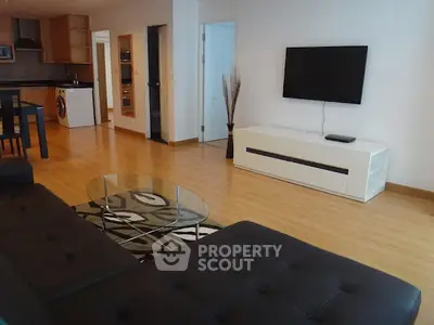 Spacious modern living room with sleek furniture and open kitchen layout.