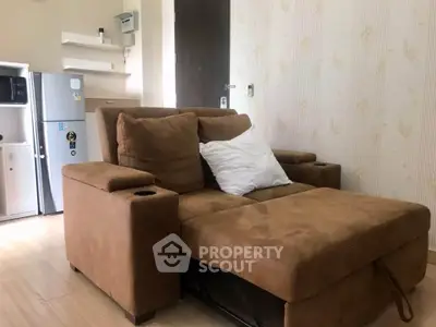 Cozy living room with plush brown sofa and modern mini fridge, perfect for relaxation.