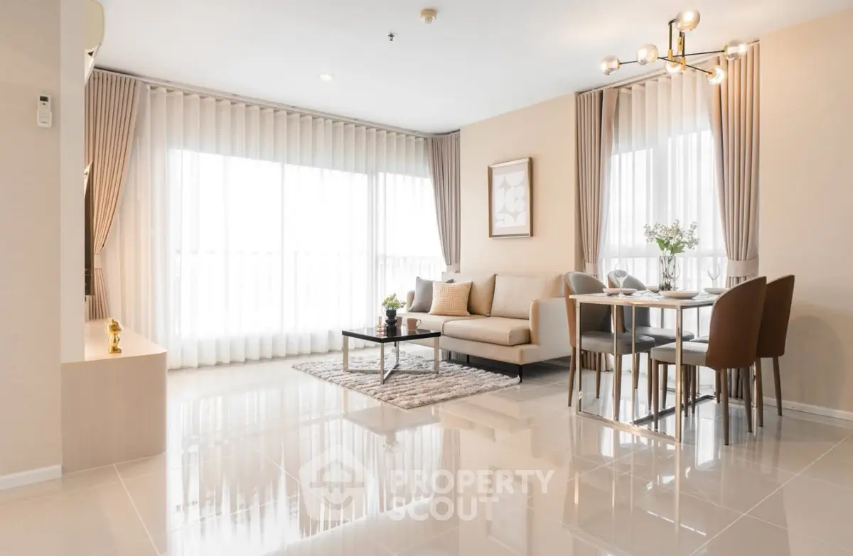 Modern living room with elegant decor, large windows, and stylish furniture in a bright, open space.