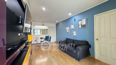 Modern living room with sleek design, featuring a cozy sofa, wall-mounted TV, and stylish dining area.
