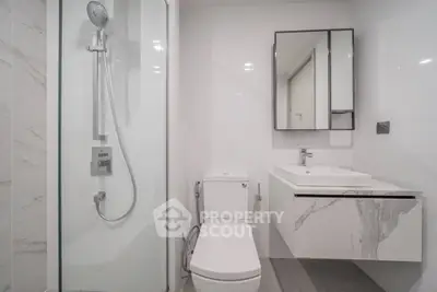 Modern bathroom with sleek shower and elegant marble sink design.