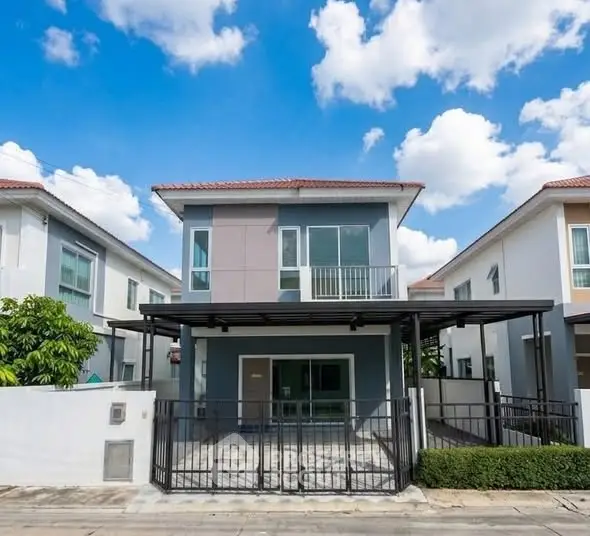 Modern two-story house with sleek design and spacious driveway in a suburban neighborhood.