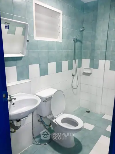 Modern bathroom with blue and white tiles, featuring a shower and toilet.